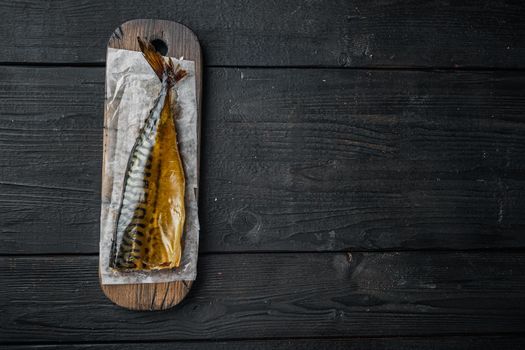 Smoked fish mackerel, on black wooden table background, top view flat lay with copy space for text