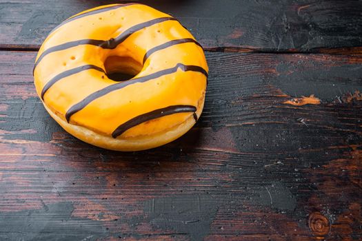Orange fresh Donut, on old dark wooden table background with copy space for text