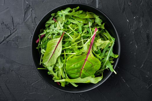 Mix Salad leafs, Swiss chard and Arugula set, on black stone background, top view flat lay, with copy space for text