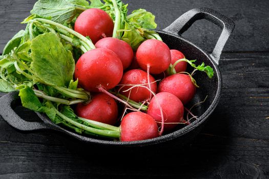 Small garden radish set, on black wooden table background