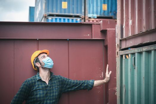 Transport Engineer Man Wearing Medical Face Mask for Prevention Coronavirus Epidemic Situation in Containers Logistic Shipping Yard. Transportation and Logistics after Coronavirus Covid-19 New Normal