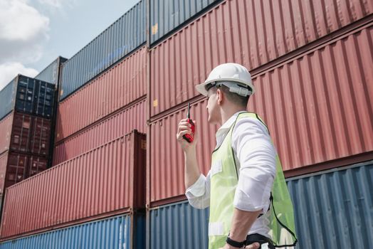 Container Logistics Shipping Management of Transportation Industry, Transport Engineer Managing Control Via Walkie Talkie in Containers Shipyard. Business Cargo Ship Import/Export Factory Logistic.