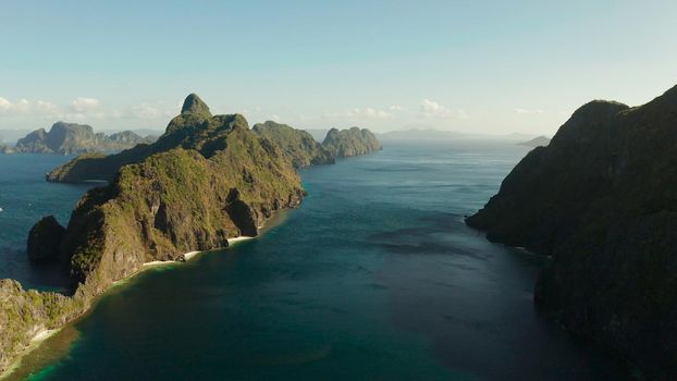 Bay and the tropical islands. Seascape with tropical rocky islands, ocean blue wate, aerial view. islands and mountains covered with tropical forest. El nido, Philippines, Palawan. Tropical Mountain Range