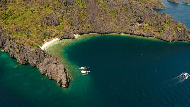 Aerial drone tropical landscape bay with beach and clear blue water surrounded by cliffs. El nido, Philippines, Palawan. Seascape with tropical rocky islands, ocean blue water. Summer and travel vacation concept