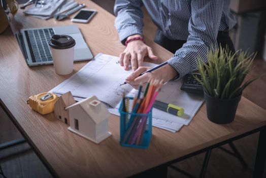 Architect Woman is Working Architecture Drawing Layout and Detail Drafting on Table Desk in Home Office, Female Designer is Creative Sketching for Construction. Architect Occupation/Creativity Concept
