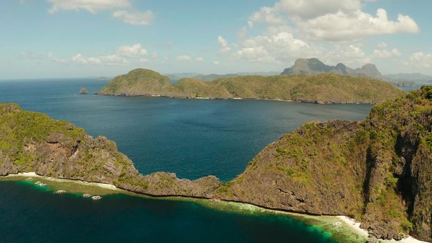 Seascape with tropical rocky islands, ocean blue water, aerial view . islands and mountains covered with tropical forest. El nido, Philippines, Palawan. Tropical Mountain Range
