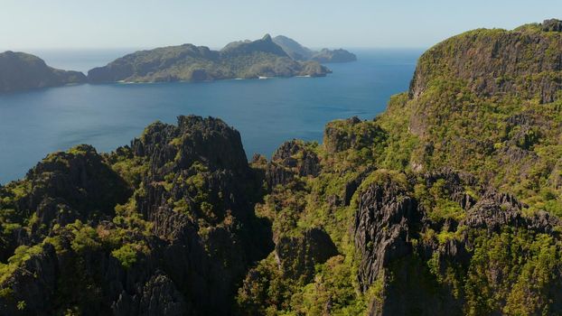 aerial view of bay and the tropical islands. Seascape with tropical rocky islands, ocean blue water. islands and mountains covered with tropical forest. El nido, Philippines, Palawan. Tropical Mountain Range