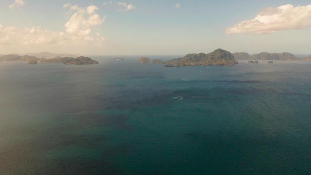 Seascape with tropical rocky islands, ocean blue water, aerial view . islands and mountains covered with tropical forest. El nido, Philippines, Palawan. Tropical Mountain Range
