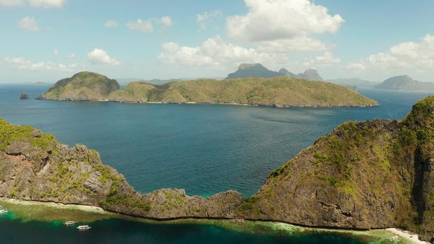 Seascape with tropical rocky islands, ocean blue water, aerial view . islands and mountains covered with tropical forest. El nido, Philippines, Palawan. Tropical Mountain Range