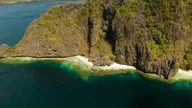 Tropical lagoon with sandy beach surrounded by cliffs, aerial view. El nido, Philippines, Palawan. Seascape with tropical rocky islands, ocean blue water. Summer and travel vacation concept
