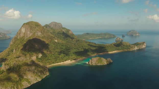 Seascape with tropical bay, rocky islands, ocean blue water, aerial view. islands and mountains covered with tropical forest. El nido, Philippines, Palawan. Tropical Mountain Range