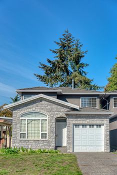 Half of residential duplex house on bright sunny day with blue sky background