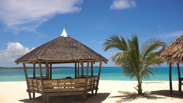 Beach with white sand with beach house on a tropical island Daco. Beautiful sky, sea, resort. Seascape: Ocean and beautiful beach paradise. Philippines. Travel concept.