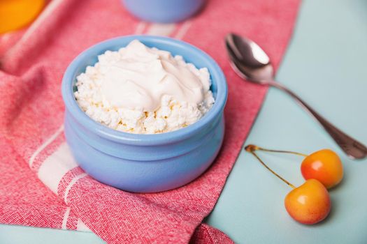 Cottage cheese in a blue bowl with sour cream and honey. Morning breakfast.