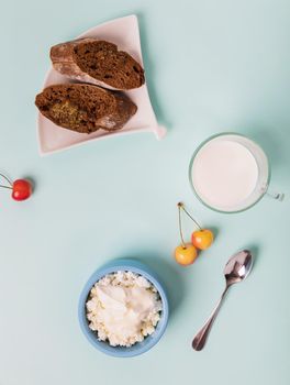 Cottage cheese in a blue bowl with sour cream and honey. Toasted bread in a plate. Morning breakfast.