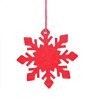 Hanging wooden snowflake Christmas tree ornament isolated on a white background.