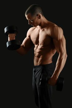 Focused on fitness. Masculine shirtless male pumping iron showing off his sexy ripped body