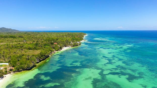 Coast with a sandy beach and azure water surrounded by a coral reef. Bohol, Anda, Philippines. Summer and travel vacation concept.