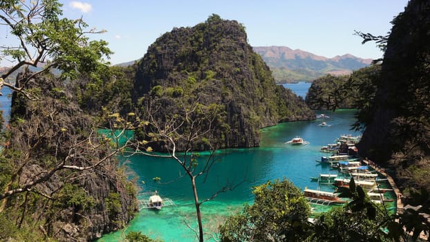 Tropical lagoon with azure water, beach by the Kayangan Lake, Philippines. View Coron island, with cove, bay at Kayangan lake. Lagoon with sailing boats. Philippines. Travel concept