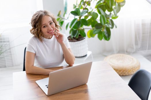 Business woman using laptop sitting near desk white office interior with houseplant looking at camera Business people Business person Online, Young and successful Dresed white shirt
