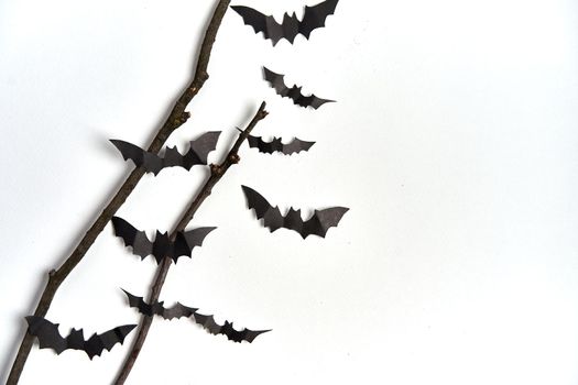 Halloween decoration concept black paper bats dry branch stick white cardboard background With copy space for tetxt
