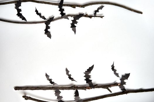 Halloween decoration concept black paper bats dry branch stick white cardboard background With copy space for tetxt