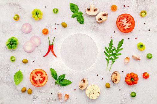 The ingredients for homemade pizza set up on white concrete background.