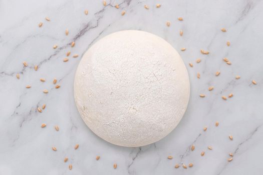 Fresh raw homemade yeast dough resting on marble table flat lay.