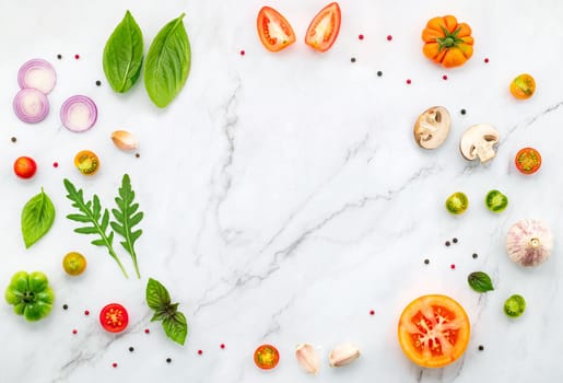 The ingredients for homemade pizza set up on white marble background.