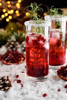 Glass with pomegranate Margarita with candied cranberries, rosemary. Perfect cocktail for a Christmas party