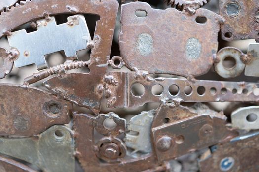 Grunge Background Rusty metal parts. Gears, fittings, wires, tubes other old products are welded to uneven iron sheets. Perfect for background and grunge design.