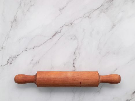 The rolling pin set up on white marble background. Baking background with the rolling with flat lay and free space for text.