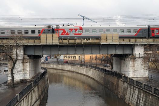 March 10, 2019 Moscow, Russia. A Russian Railways passenger train rides across a bridge over the Yauza River in Moscow.