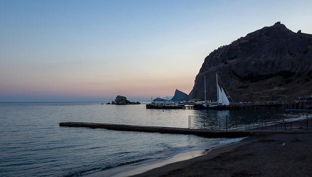 Sailing boats at the pier at the foot of the Fortress Mountain in Sudak.