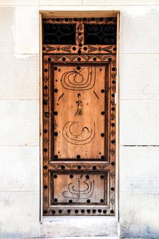 Old and colorful wooden door with iron details in Alicante, Spain