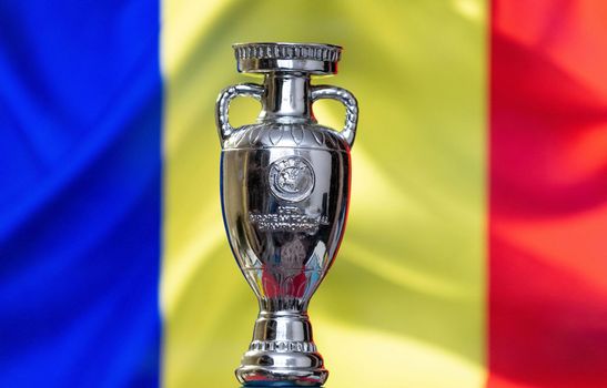 April 10, 2021. Bucharest, Romania. UEFA European Championship Cup with the Romanian flag in the background.