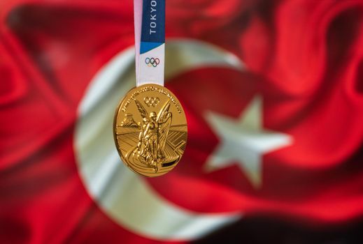 April 25, 2021 Tokyo, Japan. Gold medal of the XXXII Summer Olympic Games 2020 in Tokyo on the background of the flag of Turkey.
