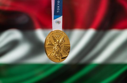 April 25, 2021 Tokyo, Japan. Gold medal of the XXXII Summer Olympic Games 2020 in Tokyo on the background of the flag of Hungary.