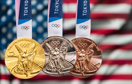 April 25, 2021 Tokyo, Japan. Gold, silver and bronze medals of the XXXII Summer Olympic Games 2020 in Tokyo on the background of the US flag.