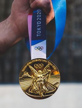 April 17, 2021 Tokyo, Japan. The gold medal of the XXXII Summer Olympic Games in Tokyo in the hand of an athlete.