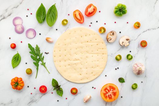 The ingredients for homemade pizza set up on white marble background with copy space and top view.
