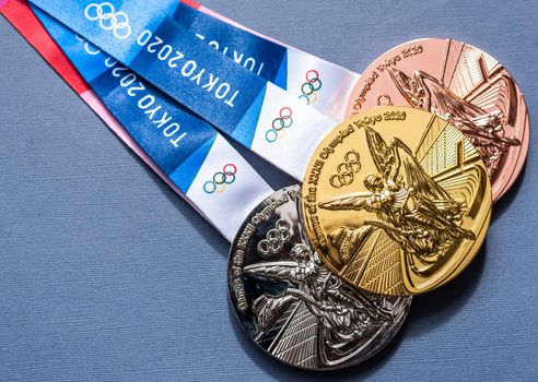 April 25, 2021 Tokyo, Japan. Gold, silver and bronze medals of the XXXII Summer Olympic Games in Tokyo on a dark blue background.