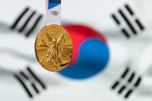 April 25, 2021 Tokyo, Japan. Gold medal of the XXXII Summer Olympic Games 2020 in Tokyo on the background of the flag of South Korea.