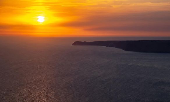 The sun setting into the sea and the long cape crashing into the Black Sea at sunset. Coast of the Crimean Peninsula near Balaklava.