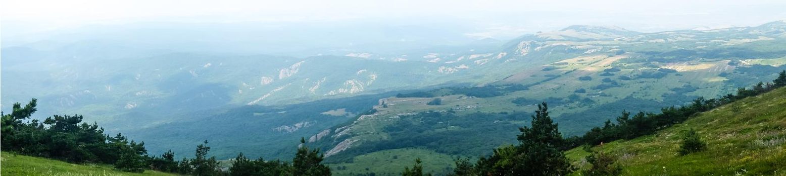 A view of the mountains covered with dense forest from the upper plateau of the Chatyr-Dag mountain range in Crimea. Panorama