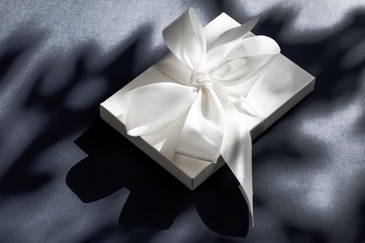 Anniversary celebration, shop sale promotion and luxe surprise concept - Luxury holiday white gift box with silk ribbon and bow on black background, luxe wedding or birthday present