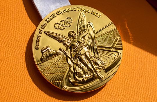 April 25, 2021 Tokyo, Japan. Gold medal of the XXXII Summer Olympic Games in Tokyo on a yellow background.