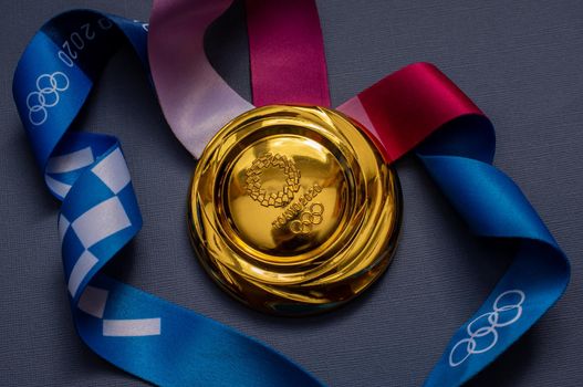 April 25, 2021 Tokyo, Japan. Gold medal of the XXXII Summer Olympic Games in Tokyo on a blue background.
