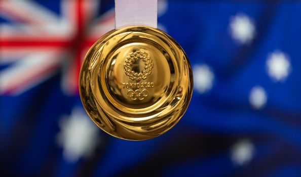 April 25, 2021 Tokyo, Japan. Gold medal of the XXXII Summer Olympic Games 2020 in Tokyo on the background of the flag of Australia.