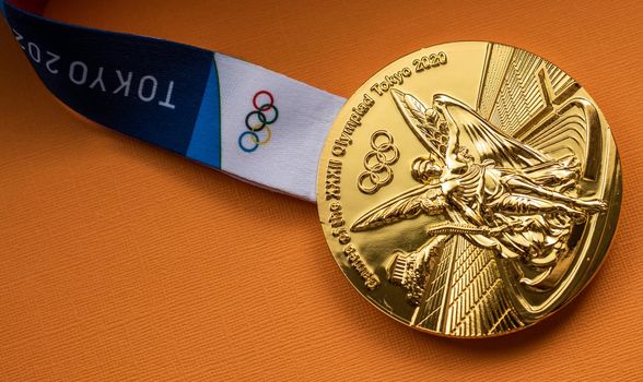 April 25, 2021 Tokyo, Japan. Gold medal of the XXXII Summer Olympic Games in Tokyo on a yellow background.
